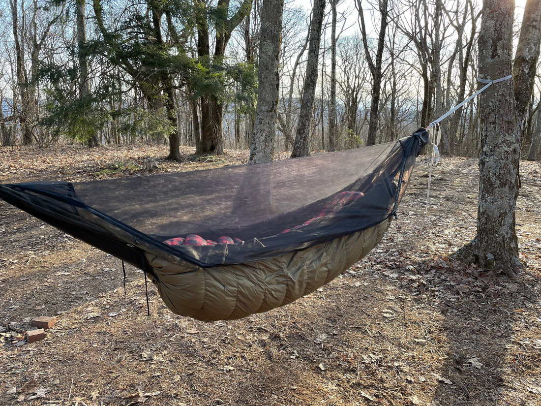 Jacks R Better down hammock underquilt with bug net hung in a winter forest on a mountain ridge