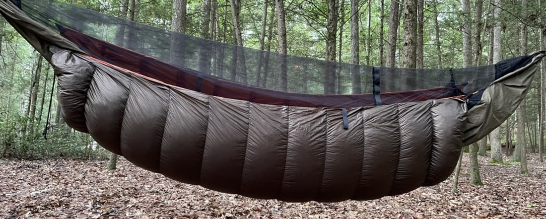 Jacks R Better brown down hammock underquilt hanging beneath a hammock in an autumn forest