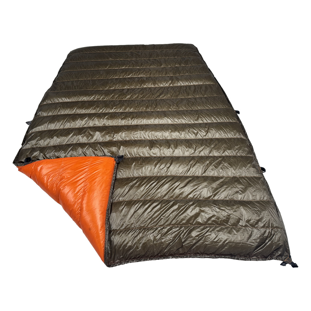 Big Meadows Ultralight 20° quilt with the foot corner turned back, showing the burnt orange interior against the dark olive shell