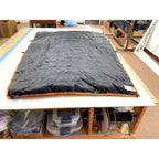 Custom ultralight backpacking quilt in Black with Burnt Orange edge trim, laid flat