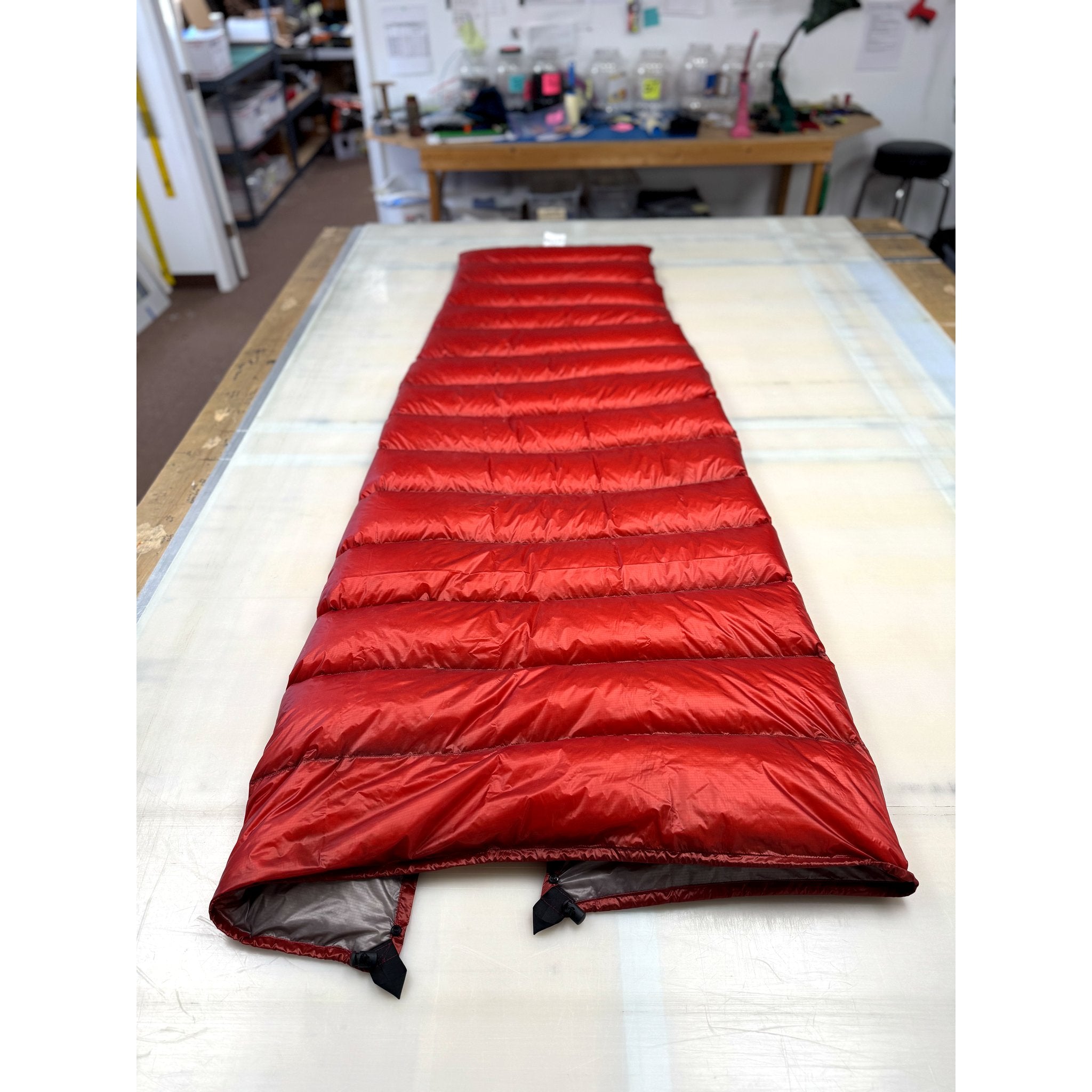 Custom ultralight backpacking quilt in solid Brick Red, laid out full length