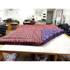 Custom ultralight backpacking quilt in a Buffalo Plaid print, red and black check, with a Purple lining