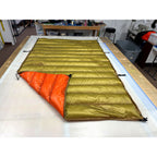 Custom ultralight backpacking quilt with a Moss Green shell and Burnt Orange lining, corner folded back