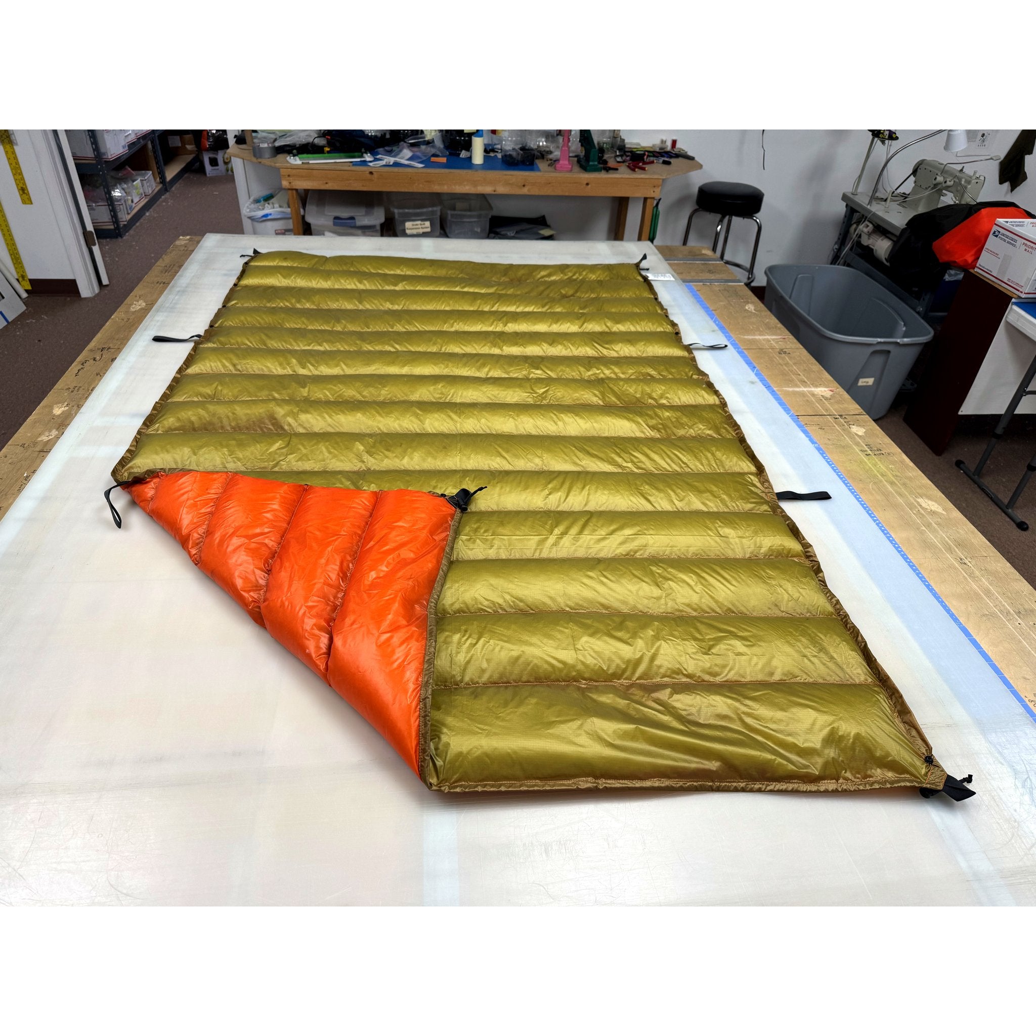 Custom ultralight backpacking quilt with a Moss Green shell and Burnt Orange lining, corner folded back