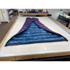 Custom ultralight backpacking quilt in Purple and Moroccan Blue, opened flat to show the two-tone interior