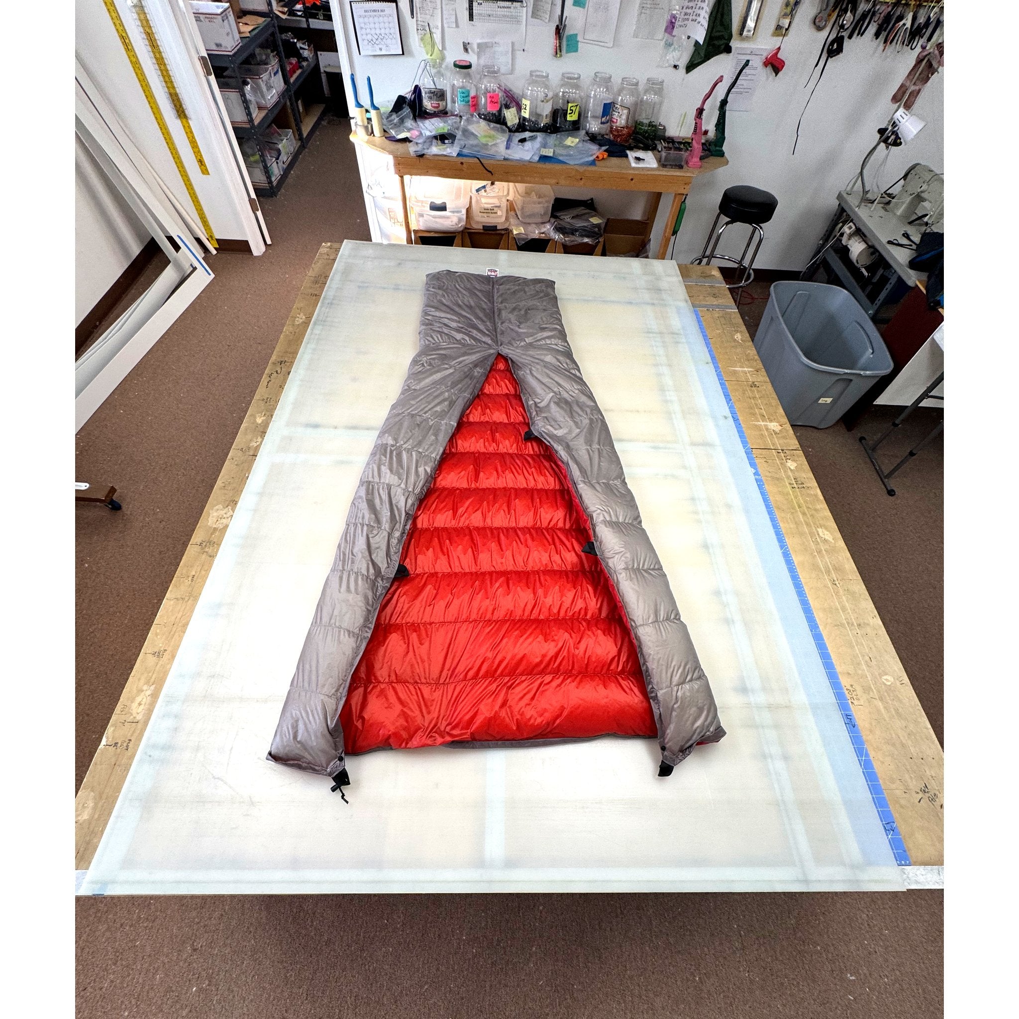 Custom ultralight backpacking quilt with a Titanium Grey shell and Brick Red lining, opened to show the interior