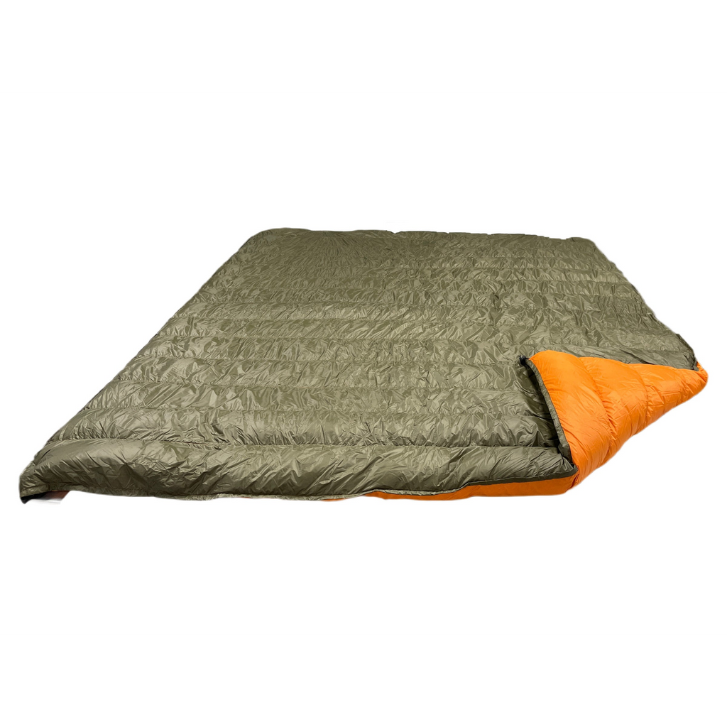 Jacks R Better Overland 20°F overlanding and RV camping quilt laid flat, dark olive shell with the corner turned back to show the burnt orange lining