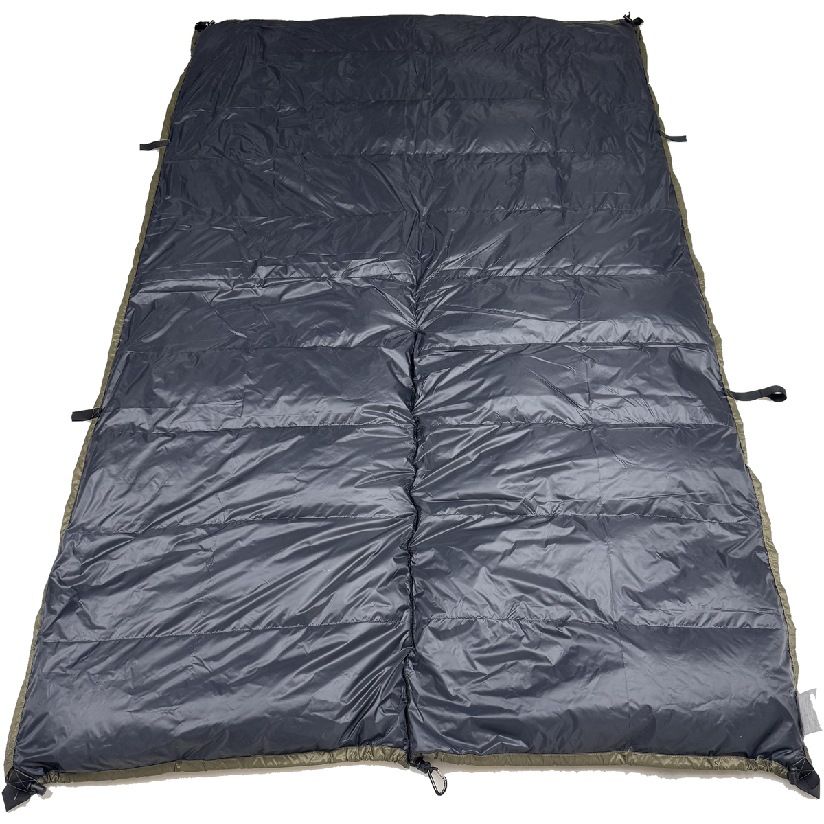 Jacks R Better The Nest 20 degree Hennessy Hammock underquilt laid flat with the black side facing up and olive edge binding visible