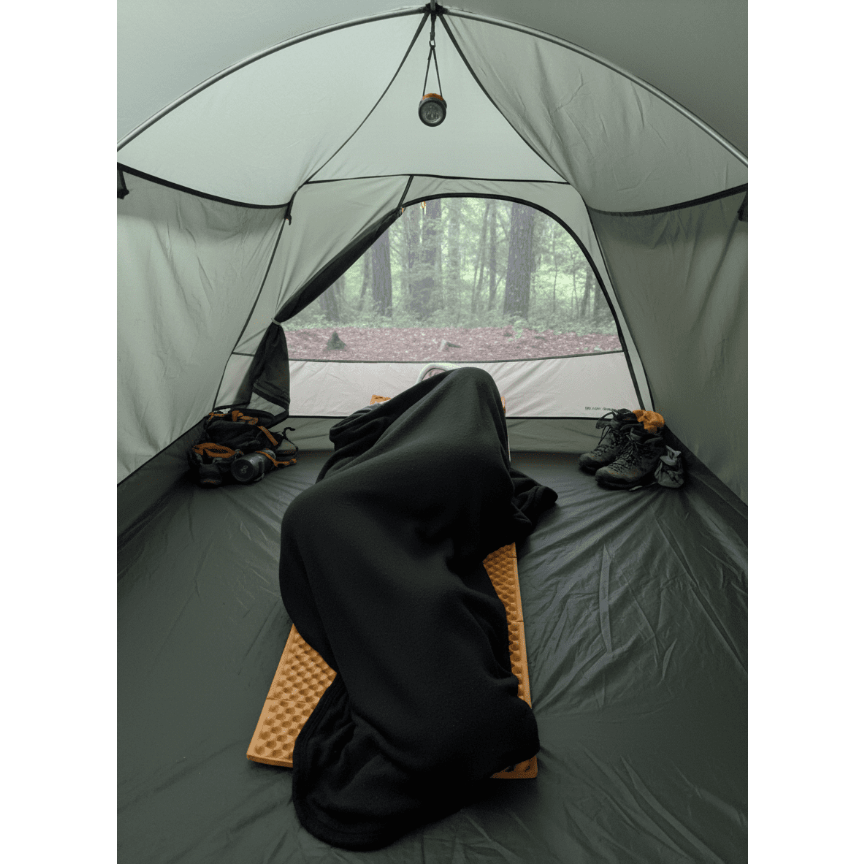 Black Polartec Alpha Direct Quilt Liner used as a stand alone blanket on a camping mat inside a tent — ultralight backpacking sleep system